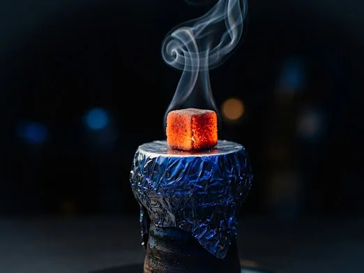 Glowing AFZALARANG coconut charcoal cube on a shisha bowl